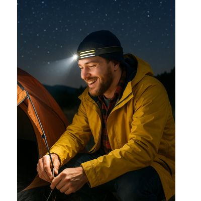 lampe frontale homme auprès du bivouac