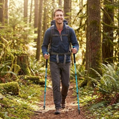 Bâtons de marche randonnée homme en sentier forestier