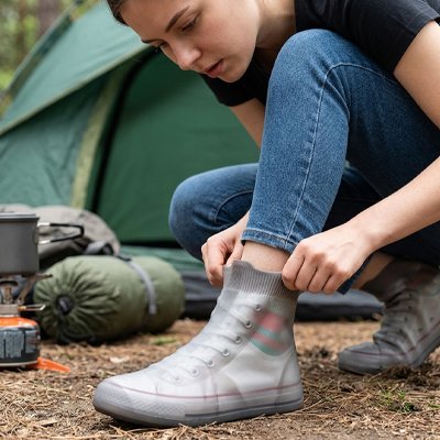 couvre chaussure​ imperméable femme qui les enfile pour sa randonnée