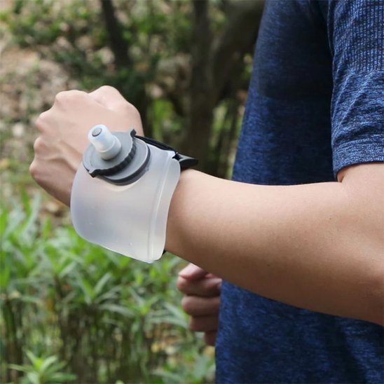 gourde plastique blanche au poignet d'un homme en randonnée