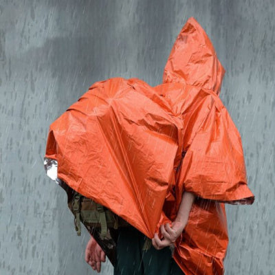 Poncho pluie orange par dessus sac à dos