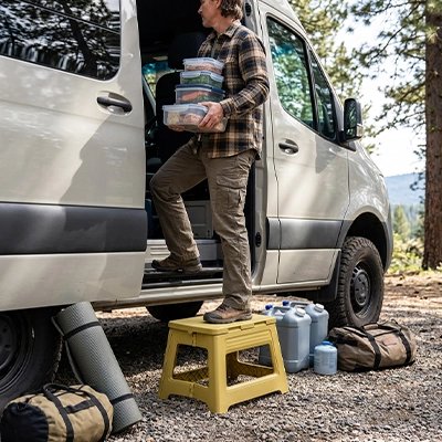 tabouret pliable homme qui organise son vanlife