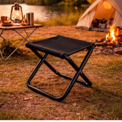 Tabouret pliable noir près du bivouac en camping
