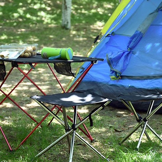 Tabouret pliable noir près du bivouac