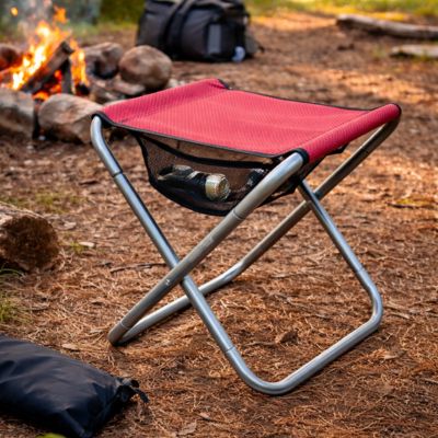 Tabouret pliable rouge près du feu de camp