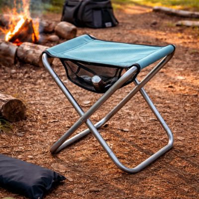 Tabouret pliable vert près du feu